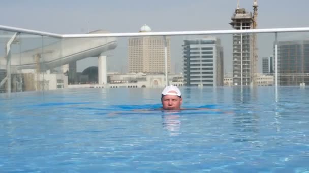 Dubai, Förenade Arabemiraten, Uae - 20 November 2017: kaukasiska Traveler man nära Mall of the Emirates, al khoory hotel swimmingpool på taket, koppla av, bada, njuta av urban utsikt — Stockvideo