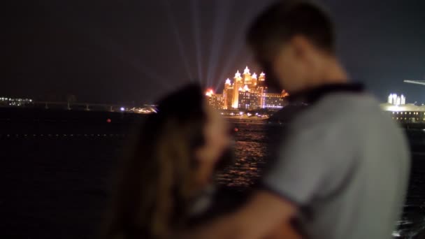 DUBAI, EMIRATOS ÁRABES UNIDOS, Emiratos Árabes Unidos - 20 de noviembre de 2017: Atlantis The Palm, Dubai. Atlantis hotel iluminado por la noche, pareja enamorada admira la belleza del hotel por la noche — Vídeo de stock