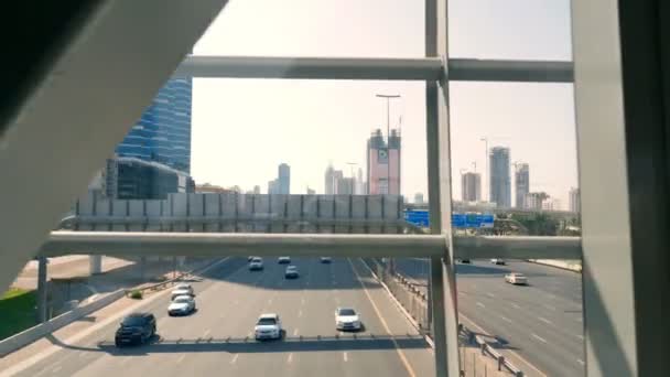 Dubai, Förenade Arabemiraten, Uae - 20 November 2017: Trafiken rör sig längs en upptagen stad väg i eftermiddag. En vy från automatisk gångväg på Dubai Metro Station — Stockvideo