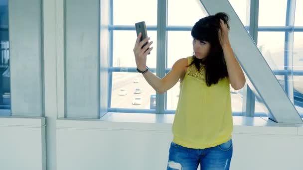 かなり若いブルネットの少女は、地下鉄を横断、スマート フォンを使用して selfie、します。, — ストック動画