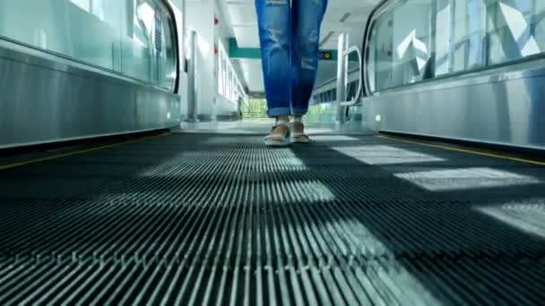 Jambes de femme en sandales debout sur le trottoir automatique, sur l'escalier roulant à la station de métro dans la ville — Video