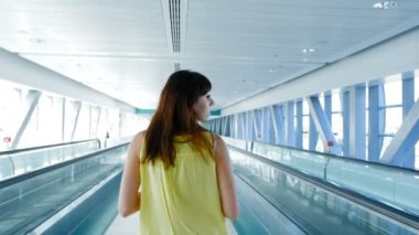 Arkadan Görünüm, otomatik yürüyüş yolları crossing, konuşurken, ona telefon, iletişim, ortalaması kullanarak Metro arasında yürüyen kadın Gadget'ı. Her zaman temas halinde bir kavramdır.