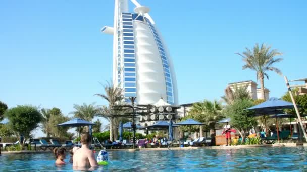 Dubaj, Spojené arabské emiráty, SAE - 20. listopadu 2017: Hotel Jumeirah Al Naseem, poblíž Burj al Arab. Rodinná dovolená s malé děti, relaxovat u bazénu. , lidi hrát, plavat v bazénové vodě — Stock video
