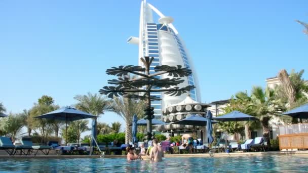 DUBAI, UNITED ARAB EMIRATES, Emirados Árabes Unidos - NOVEMBRO 20, 2017: Hotel JUMEIRAH AL NASEEM, perto de Burj al Arab. férias em família com bebês pequenos, relaxar perto da piscina. , as pessoas brincam, nadam na água da piscina — Vídeo de Stock