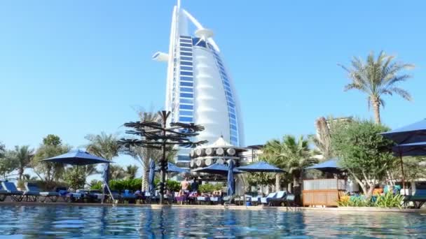 Dubai, Egyesült Arab Emírségek, Uae - November 20, 2017: Gyönyörű medence hotel Al Naseem Madinat Jumeirah-kilátással a Burj Al Arab Hotel. — Stock videók