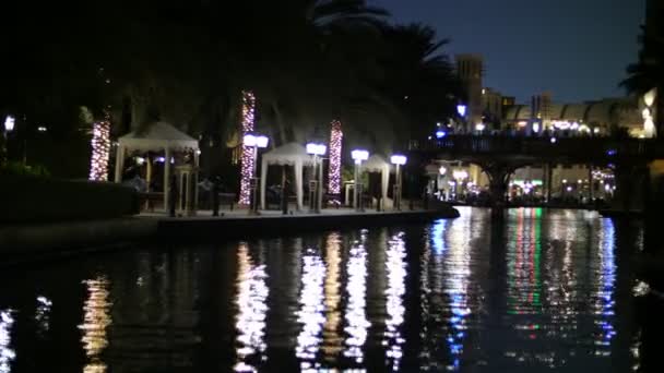 Dubai, Egyesült Arab Emírségek, Uae - November 20, 2017:Hotel Jumeirah Al Qasr Madinat, éjszakai séta a víz-csatorna, egy hajón. A lámpák világítanak az épületek — Stock videók