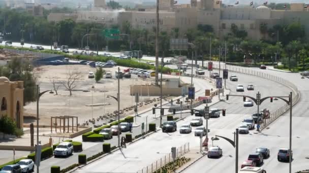 迪拜, 阿拉伯联合酋长国, 阿联酋-2017年11月20日: 交通沿着繁忙的城市道路在下午移动。来自上面的视图。机动车路通过城市. — 图库视频影像