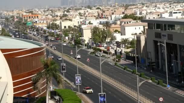 Dubai, Verenigde Arabische Emiraten, Verenigde Arabische Emiraten - 20 November 2017: Verkeer beweegt langs een weg van de drukke stad in middag. Een weergave van bovenaf. autoweg door de stad. — Stockvideo