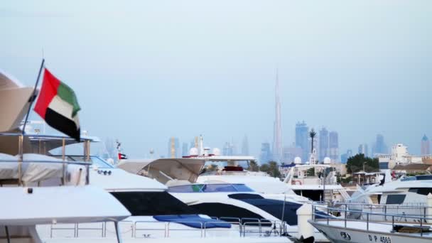 阿联酋迪拜酒店-2017年11月20日: 码头附近的玛丽娜阿拉伯, 有许多美丽的停泊游艇反对摩天大楼远在地平线上. — 图库视频影像