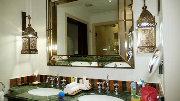 Dubaj, Spojené arabské emiráty, SAE - 20. listopadu 2017: Hotel Jumeirah Al Qasr Madinat, moderní a luxusní koupelna, zařízené v arabském stylu, s velkým zrcadlem na zeď. — Stock video