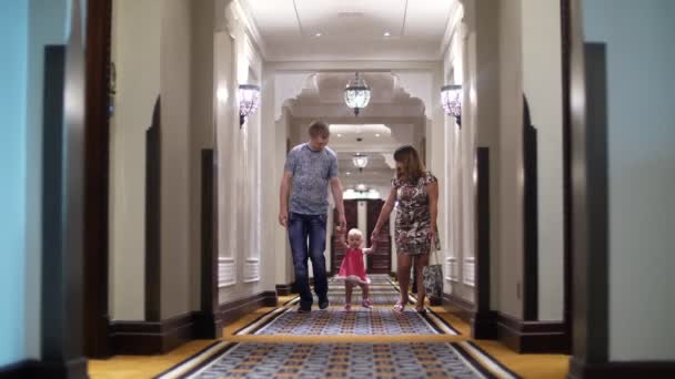 DUBAI, UNITED ARAB EMIRATES, UAE - NOVEMBER 20, 2017: Hotel Jumeirah Al Qasr Madinat, beautiful corridor of an expensive hotel. молодая пара с ребенком, идущая вдоль него — стоковое видео