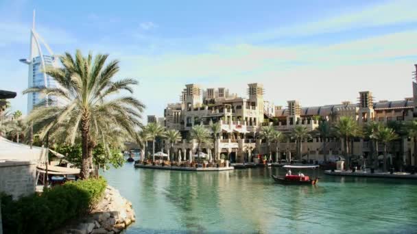 DUBAI, UNITED ARAB EMIRATES, UAE - NOVEMBER 20, 2017: Hotel Jumeirah Madinat, near Burj al Arab. прогулка на лодке Арба по водному каналу в гостиничном комплексе. семейное призвание — стоковое видео