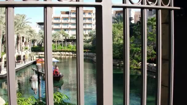 Dubai, Verenigde Arabische Emiraten, Verenigde Arabische Emiraten - 20 November 2017: Hotel Jumeirah Madinat, dag Arba boottocht op het water kanaal, in de zon, in het hotelcomplex. familie roeping — Stockvideo