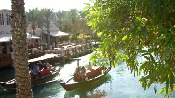DUBAI, UNITED ARAB EMIRATES, Emirados Árabes Unidos - NOVEMBRO 20, 2017: Hotel Jumeirah Madinat, passeios de barco de dia Arba no canal de água, à luz do sol, no complexo hoteleiro. vocação familiar — Vídeo de Stock