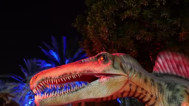 Dubai, Förenade Arabemiraten, Uae - 20 November 2017: Dinosaur Park på Dubai trädgård glöd park, upplyst på natten. en hel del olika dinosaurier, ser levande — Stockvideo