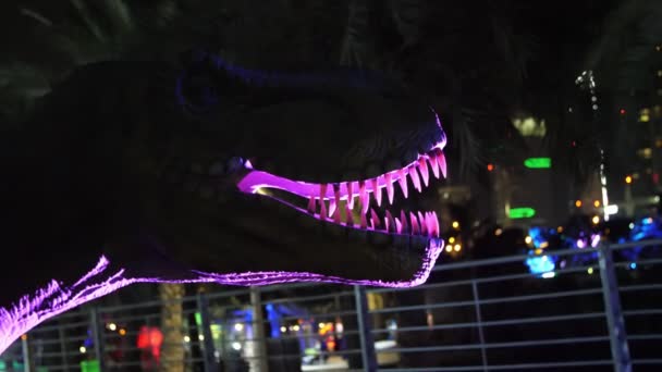 DUBAI, UNITED ARAB EMIRATES, UAE - NOVEMBER 20, 2017: Dinosaur Park at Dubai Garden Glow park, opplyst om natten. Mange forskjellige dinosaurer, se levende ut – stockvideo