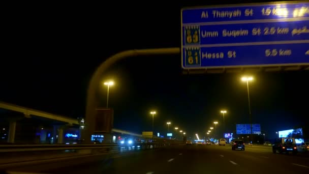 Dubai, Об'єднані Арабські Емірати, ОАЕ - 20 листопада 2017: ніч міста Дубай, доріг освітлений ліхтарі, багато автомобілів, все місто освітлюється, вид з рухомих таксі — стокове відео