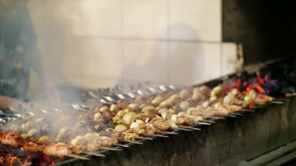 На грилі приготування шашлику на металевому шампурі крупним планом. Запечене м'ясо, приготоване на барбекю. Гриль на вугіллі та полум'ї, пікнік, вулична їжа — стокове відео