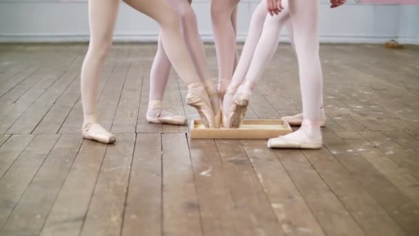 Primer plano, los pies de los bailarines jóvenes, las niñas bajan las puntas de los zapatos de punta en una caja con polvo especial — Vídeo de stock