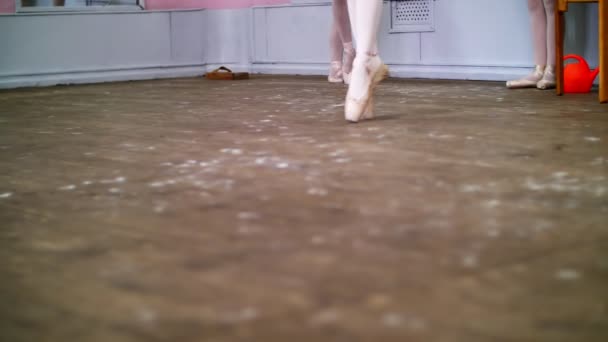 Da vicino, in classe di danza classica, su un vecchio pavimento di legno, ballerina esegue glissade en tournant, Si muove attraverso la classe di balletto elegantemente , — Video Stock