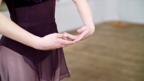 Primer plano, en salón de baile, Joven bailarina en maillot púrpura realiza la primera posición de las manos, elegantemente , — Vídeos de Stock