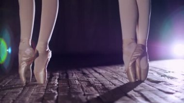 eski tiyatro salonu sahnede spot, ışınları kapatın. ayak pointe yerinde duran balerinler gerçekleştirir zarif bir bale egzersiz, pas de Bourré suivi