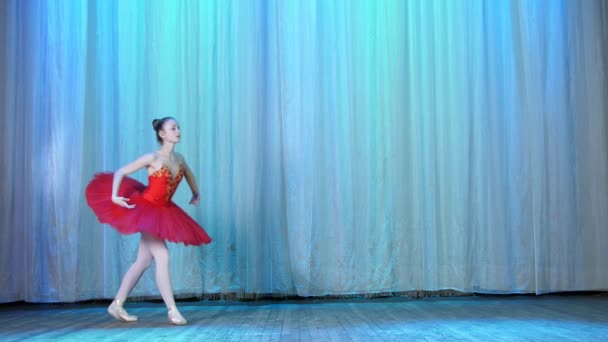 Ballettprobe, auf der Bühne des alten Theatersaals. junge Ballerina in rotem Balletttutu und Spitzenschuhen, tanzt elegant bestimmte Ballettbewegungen, Pas courru, Tourfouette — Stockvideo