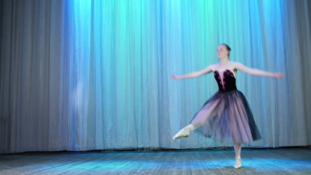 Ensayo de ballet, en el escenario de la antigua sala de teatro. Bailarina joven en vestido elegante negro lila y zapatos puntiagudos, baila elegantemente cierto movimiento de ballet, ensambla ferme — Vídeo de stock