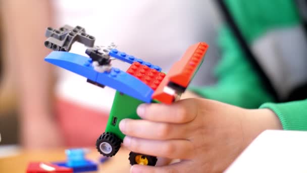 Close-up, childrens hands hold a multicolored small car assembled from a designer — Stock Video