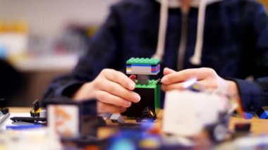 yakın çekim, çocuk eller çok renkli küçük bir robot, makine, bir tasarımcıdan toplandı. çocuklar Robotik, ilgilenirseniz programlama, modelleme,