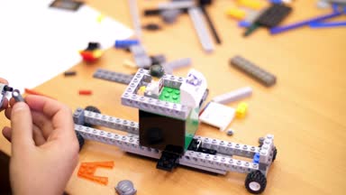 yakın çekim, çocuk eller çok renkli küçük bir robot, makine, bir tasarımcıdan toplandı. çocuklar Robotik, ilgilenirseniz programlama, modelleme,