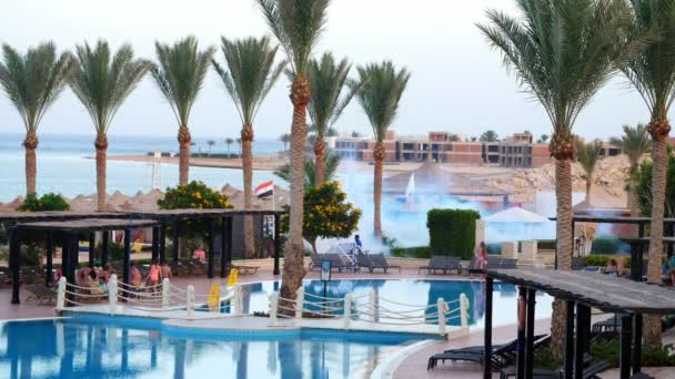 SHARM EL SHEIKH, EGIPTO - 5 DE ABRIL DE 2018: Hotel Jaz Belvedere. en el territorio del hotel, el personal envenena a los mosquitos con una máquina de humo especial. De los arbustos, sobre el fondo del mar — Vídeo de stock