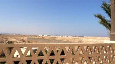 Çölde otel balkon manzarası. Uzaktan görünür durumda tamamlanmamış otel kompleksleri.