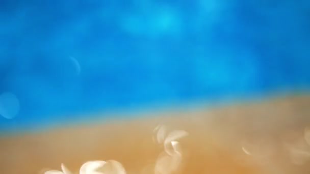 Close-up, focus in blur, two element, water and sand in light, reflections — Stok Video