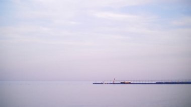 İskele, Kızıldeniz, rüzgarsız sakin hava, gökyüzünde bulutlar vardır, uzun bir iskelesi ufukta görebilirsiniz