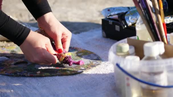 Nahaufnahme, weibliche Hände mit knallroter Maniküre. der Künstler drückt etwas weinrote Farbe aus einer Tube — Stockvideo