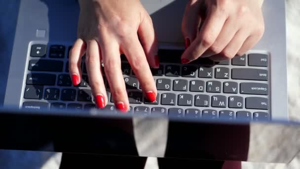 Καλοκαίρι, παραλία της θάλασσας. γκρο πλαν πάνω από γυναικεία χέρια με έντονο κόκκινο μανικιούρ, τύπου σχετικά με το πληκτρολόγιο του φορητού υπολογιστή. εργασίας για το laptop. — Αρχείο Βίντεο