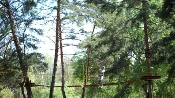 Cherkasa, 1. Mai 2018: Die Besucher genießen ihr Baumwipfelabenteuer und klettern auf dem Holzklotz, der mit dem Seil zwischen Baum und Baum hängt. Sport im Freien — Stockvideo