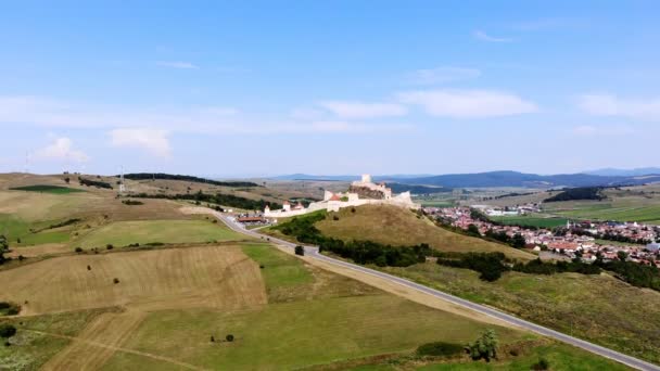 Luchtvaart. panoramisch uitzicht op het oude kasteel, Rupea verdediging fort geplaatst op de top van een heuvel. aan de voet van het kasteel ligt een klein stadje. Transsylvanië, Roemenië. zonnige hete zomerdag — Stockvideo