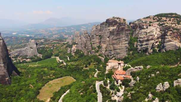 Aero. Las montañas Meteoros en Grecia. en las cimas de las maravillosas montañas hay antiguos monasterios hermosos. y debajo hay un valle verde con viñedos y pequeños pueblos . — Vídeo de stock