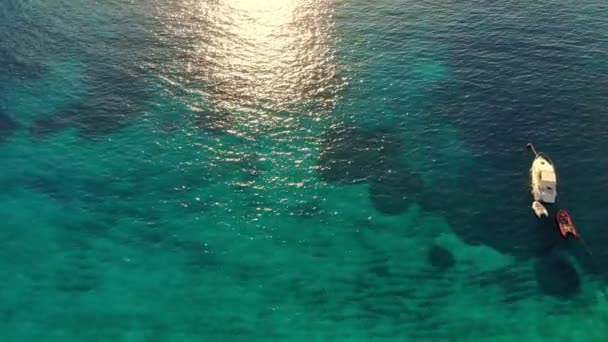 Aero, widok z góry. Turkusowa błękitna woda Morza Egejskiego w słońcu o zachodzie słońca. wybrzeże. łódź zacumowana. — Wideo stockowe