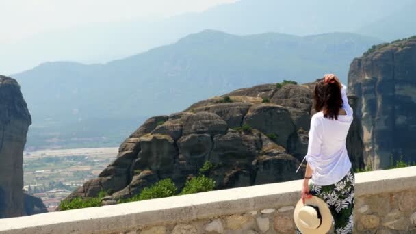 Молодая женщина восхищается чудесными горами Метеора, Греция, прекрасный пейзаж . — стоковое видео