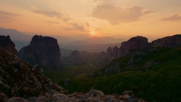 Aero, cronometragem. por do sol nas montanhas Meteoro na Grécia. mosteiros antigos estão no topo de montanhas maravilhosas e abaixo há vale verde e pequenas aldeias . — Vídeo de Stock