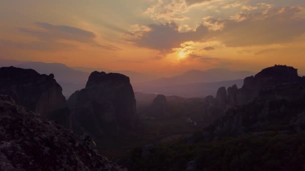 Aero, zaman ayarlı. Yunanistan 'daki Meteorlar' da gün batımı. Antik manastırlar muhteşem dağların tepesindedir. Altında yeşil vadiler ve küçük köyler vardır.. — Stok video