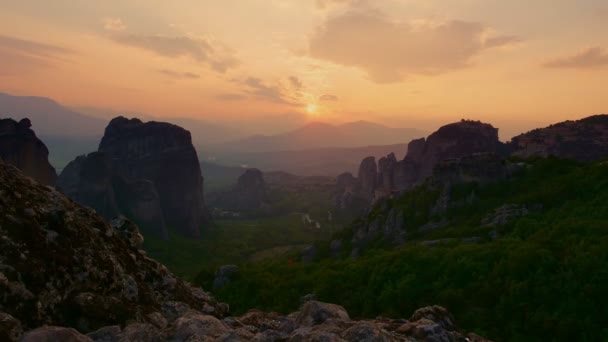 Aero, zaman ayarlı. Yunanistan 'daki Meteorlar' da gün batımı. Antik manastırlar muhteşem dağların tepesindedir. Altında yeşil vadiler ve küçük köyler vardır.. — Stok video