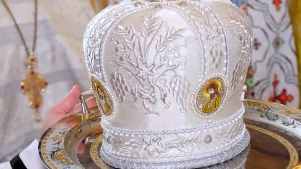 CHERKASY REGION, UKRAINE, OCTOBER 10, 2019: close-up, on a tray they hold an elegant Orthodox priests hat , a white mitre, an olemn headgear of the orthodox bishop — 비디오