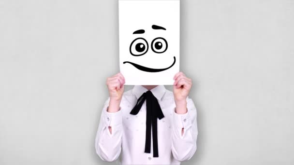Portrait, teenager holds white paper sheet with happy smiley drawing, animation, covering face. emotions, Imagination, creativity, successful idea concept. — Stock video