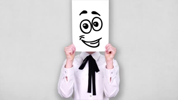 Portrait, teenager holds white paper sheet with happy smiley drawing, animation, covering face. emotions, Imagination, creativity, successful idea concept. — Stock video