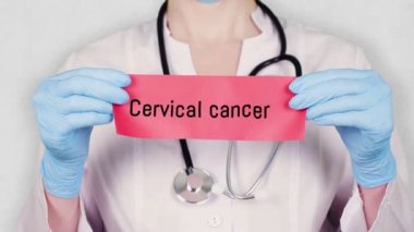Yakın plan, mavi eldivenli eller Hepatit yazısıyla kırmızı kart tutuyor ve yırtıyor. Beyaz üniformalı bir doktorun steteskobu var..