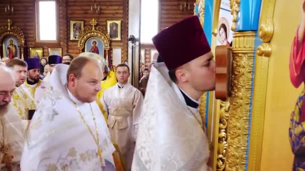 KONKURRENSREGION, UKRAINE, OKTOBER 10, 2019: Kyrkoinvigningsceremoni. präster kyssa ikonen i sin tur, delta i kyrkan rit — Stockvideo
